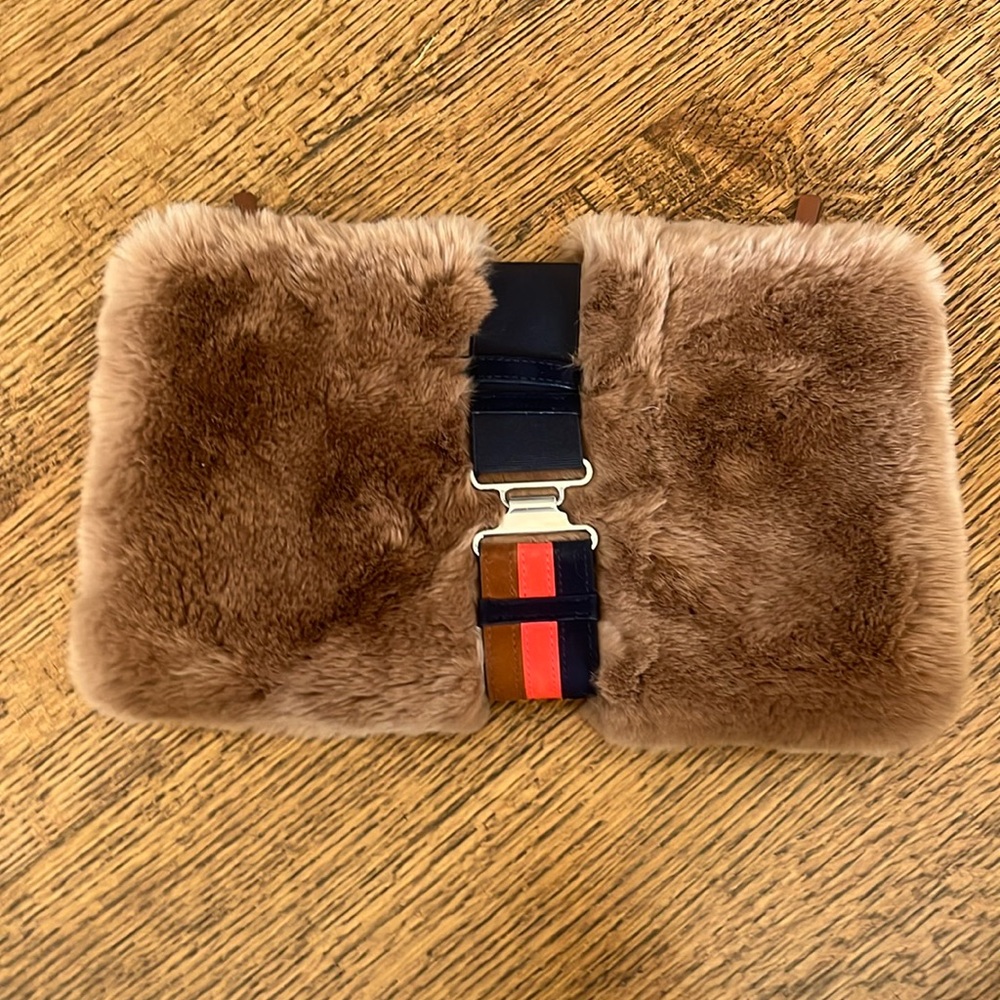 Theory fur clutch.  Tan with navy and red strap with silver closure.